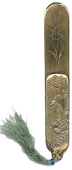 This bookmark is made in Japan between 1890 - 1910. It is made of brass with a picture of a small bird on a branch of a tree in relief on the smaller blade and a bird in flight near a plant engraved on the longer blade. This one also has the original bead and tassel at the top. The dealer said she found this with a collection of Japanese page turners that she purchased. This looks like smaller versions of them.