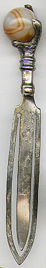 This bookmark is silver plate over brass. It has an agate sphere held by four claws of a grouse. It is a piece made between 1900 - 1920 in Scotland and was a souvenir inticating the start of the grouse hunting season.