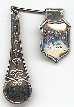 This bookmark is from Norway. It is marked N.M. BESKYTTET 830S  A N A (two horizontal A's) NORDLIE, ARNE EMANUEL  1908 - 1995 OSLO.NM stands for Norsk Mønster (Norwegian pattern) Beskyttet (protected) started using after 1929. It is a very unusual piece. The smaller part clips onto a page where the connecting bar swings to let the longer part hang over the front or back cover of the book. 