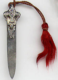 This bookmark is made in the US between 1900 - 1920 by an unknown manufacturer. The top blade is a fleur-de-lis and still has the original tassel. The back of the bottom blade is only marked sterling.
