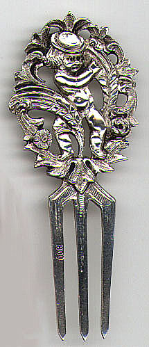 This bookmark is possibly made in France. It is only marked 800 on one of the tines but on the back is a possible mark similar to those used in France. The top of the bookmark is a boy holding a flower or something surrounded by leaves and flowers. The date is probably 1900 - 1910.