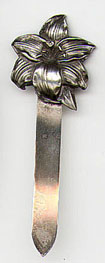 This bookmark is American made by Unger Brothers. The mark is an interlaced U and B. It has an art nouveau flower on top with a plain silver blade. This was the April flower from a set of twelve, one for each month.  