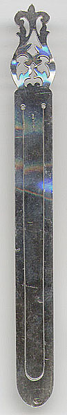 This bookmark was  made in Europe and was imported to London in 1979. The hallmarks are AB, the 1975 and greater London import mark and the date letter E for 1979. It is a long and thin piece with a fancy motif on the top.