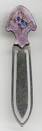This bookmark is American made by F.A. Hermann Co. The hallmark is the letter H surrounded by a black triangle followed by the word sterling. The top of the mark is lavender enamel with blue and yellow pansies. The date is probably 1900 - 1910.