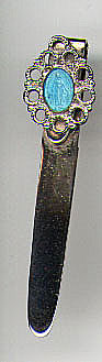 This bookmark is made in the US. It is probably new judging by the look of the silver. The top is an blue enamel of a woman surrounded by a silver design. It is marked only sterling on the back.