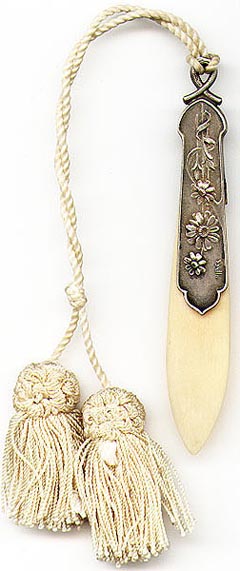 This bookmark was made in France between 1890 and 1900. It is made of celluloid and some silver metal possibly pewter or aluminum. It is signed "Offner" by the artist.