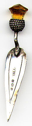 This bookmark was made in Birmingham, England in 1909. It is marked A&LLd and the marks for Birmingham and the letter k for the date of 1909. It is in the shape of a trowel with an amber citrine stone in a thistle on the top.