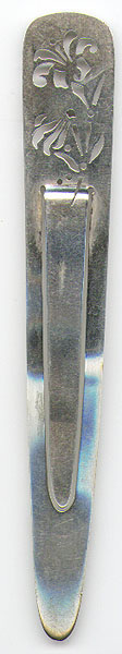 This bookmark was made in the US by Tiffany and Co. It is marked with Tiffany & Co. Makers and 18235 and the letter M. The date is 1907 - 1938. It has a cutout design of flowers at the top.