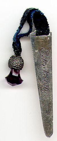 This bookmark was made in Birmingham, England in 1913 for the Scottish market. It has a blue green tartan ribbon with a thistle and a purple stone at the end. It is marked A&L Ltd and the English hallmarks. The other side is marked "Edinburgh".