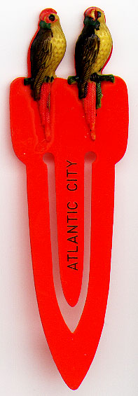 This bookmark was made in the US by an unknown manufacturer as a souvenir for Atlantic City. It is made of celluloid and has two parrots on the top. The date is 1920 - 1940.