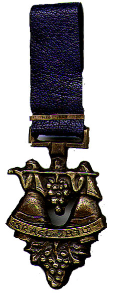 This bookmark was made in Israel in the 1950's. It is made of brass and leather and is marked "Made in Israel". It depicts two women carrying a bunch of grapes? suspended from a pole between the women. It is marked Israel in English and Hebrew.  