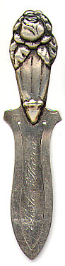 This bookmark was made in Denmark or Norway between 1910 - 1920. It is marked C.V.C.L and 830S on the back. The top is a figural rose and the middle blade is inscrbed "Foster Thora."  