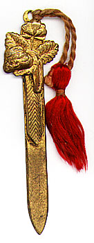  This bookmark was made in France between 1900 - 1910. It is made of brass or bronze with a red tassel. The top is a figure of a strawberry with it's flower and leaves. 