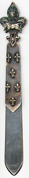  This bookmark was made in France between 1900 - 1910. It is silver plate over brass with a filigree fleur-de-lis and a bull on top and a number of fleur-de-lis' on the top blade.  