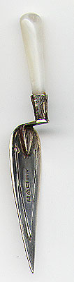 This bookmark was made in England by Addie and Lovekind. It is a masonic trowel with a mother of pearl handle. It is marked with the Chester city mark and a cursive "U" date letter for 1920.