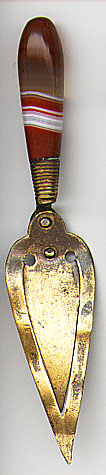  This bookmark was made in Scotland. It is made of brass and has an agate handle. It is in the shape of a trowel, a possible Masonic piece. The date is 1920 - 1930.  