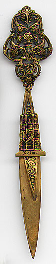  This bookmark was made in France circa 1900. It is made of brass or bronze and has a very ornate top part. The top blade has a figural cathedral and the word "Reims" inscribed under it.  