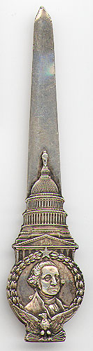 This bookmark was made in the US by Moore and Ledding, Silversmiths of Washington, DC. It is marked Sterling and Moore and Ledding and is a figural with a bust of George Washington sitting on an eagle. The top blade is the top of the Capitol Building and the botton blade is the Washington Monument. The date is 1882 - 1902.  