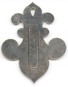 This bookmark was made in the US by Seth Ek in 1889. It is marked Sterling and the letter E. It is a figural fleur de lis. It is inscribed Easter 1889 and Emily from Katie.