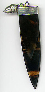 This bookmark was made in a European country probably for sale in England. It is marked Sterling Silver Prov Patent. The blades are faux tortoise shell made of Casein and are held by a silver band at the top. Attached to this band is a chain and a small silver acorn. The date is 1910 - 1920.