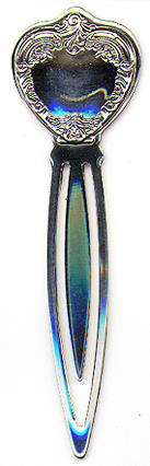 This bookmark was made in the US by Wallace Silversmiths. It is a new bookmark, made in 1998 and is marked Wallace Sterling 925. The top is a sheild in the shape of a heart with scroll work around the edges.  