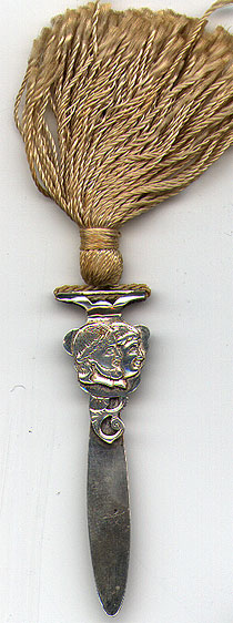 This bookmark was made in the US by Watson Company. It is marked $Sterling$ on the back. The top is pair of Roman heads with a large wheat colored tassel. The date is 1900 - 1910.