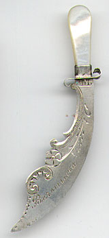  This bookmark was made in the US by an unknown manufacturer. It is in the shape of a sword with a mother of pearl handle. The second blade is behind the top blade and is marked Sterling. The date is 1900 - 1910.   