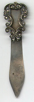 This bookmark was made in the US between 1900 - 1910. It is marked only Sterling on the back. An open wreath-like scrollwork makes up the top blade.  