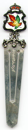 This bookmark was made in Canada between 1940 - 1960. It is marked Sterling on the back and has an enamel maple leaf in mulitple colors on the top. The top blade is inscribed Victoria.  