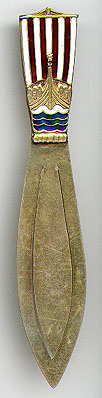 This bookmark was made in Norway. It is marked 830S with a flower symbol and the letter N. It is a front view of a Viking ship with red and white striped sails and blue water. It is finished in a gold wash. The date is 1930 - 1940.