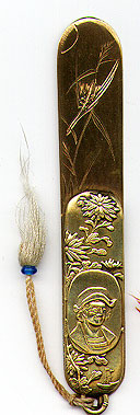 This bookmark was made in Japan. It is brass and has a medallion of a man, possibly Columbus. There are also flowers surrounding the medallion The date is 1900 - 1910.