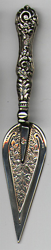 This bookmark is made in Birmingham, England. It is marked with the the date mark of 1901 and the hallmarks for Birmingham. It is in the shape of a trowel with flowers on the inner blade and flowers and scrollwork along the handle.  
