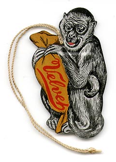 This bookmark was made in the US between 1900 - 1910. It is made of aluminum and is an advertisment for Velvet Candy. It is a lithograph of a monkey holding a bag of Velvet candy where the monkey's elbow is the cutout for the top blade.  