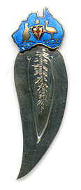 This bookmark was made in Australia by an unknown manufacturer. It is marked with a unicorn hallmark and STG. SILVER. The top of the bookmark is an enamel figural in shape of the continent of Australia with a kangaroo and emu on either side of a shield. The date is 1920 - 1930.