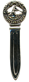 This bookmark was made in a European country. It is marked with hallmarks and N.M. 830S. The top is a woman sitting on a mound holding a stick. This scene is surrounded by a the words "Pillar Curi". The date is 1920 - 1930.