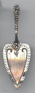 This bookmark is made in the US by R. Wallace and Sons. It is marked with the makers hallmark and sterling. It is a figural trowel or pie server and was a giveaway of the manufacturer. The top blade says "Complements R. Wallace & Sons Mfg Co Silversmiths. 226 5th Ave. New York." The date is 1900 - 1910.  