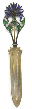 This bookmark is made in Norway by David Andersen. It is marked with his hallmark and 925. The David Andersen mark is described by the firm as a hammer and tong design, with the hammer in the center. It came into use in 1888. Norwegian law requires the degree of fineness to be followed by the letter S for silver. David Andersen chose to incorporate the S into their punch. Often the S was crossed by a diagonal line. The top of the bookmark is plique-a-jour with green and blue enamel. The date is 1890 - 1910.