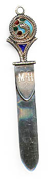 This bookmark was made in the US by an unknown manufacturer. It is marked sterling. The top has an enamel design in plique-a-jour. The date is 1900 - 1910.  
