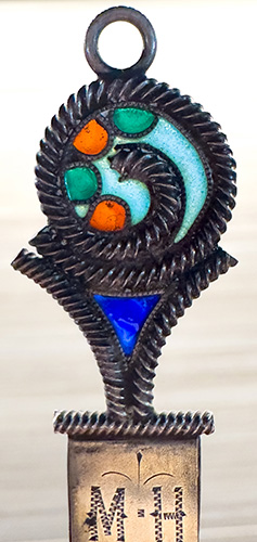 This bookmark was made in the US by an unknown manufacturer. It is marked sterling. The top has an enamel design in plique-a-jour. The date is 1900 - 1910.  