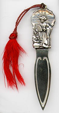 This bookmark was made in the US by an unknown manufacturer. It is marked Sterling front on the back. It is a figural of a Geisha holding an umbrella and a fan. The date is 1900 - 1910.  