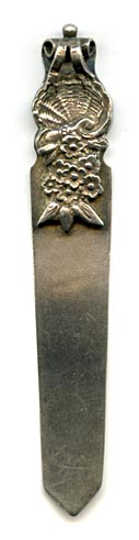 This bookmark was made in the US by Gorham Mfg. Company. It is marked with the manufacturers mark, sterling and 30, the number from the Autumn 1888 catalogue. The top blade is a figural basket of flowers. 