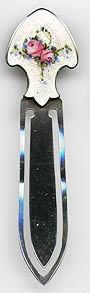 This bookmark was made in the US by F.A. Hermann Co. It is marked with a hallmark of the letter H inside of a triangle and Sterling. The top is an enamel with flowers. The date is 1900 1910. 