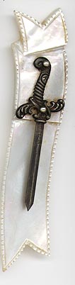 This bookmark was made in the US by an unknown manufacturer. It is marked Sterling on the blade of the sword. It is mother of pearl in the shape of a ribbon and the top blade is a sword. The date is 1900 - 1910.