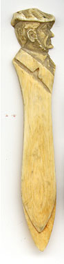 This bookmark was made by an unknown manufacturer. It is ivory or bone and has a hand carved highly detailed side view of a man's head  wearing a cap on top. The date is 1900 - 1910.