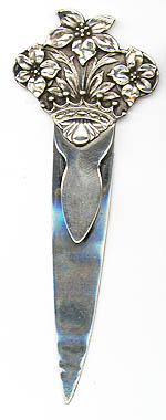 This bookmark was made in the US by Tiffany & Co. It is marked Tiffany and Co. Makers Sterling on the back. The top is a figural of three flowers rising from a crown. The date is 1900 - 1910.
