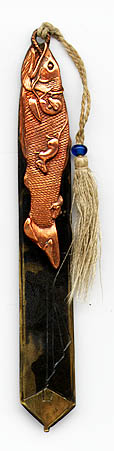 This bookmark was made in Japan, is unmarked and made of copper and brass. The top blade is copper and depicts a fish with rats running on and around it. The bottom blade is brass. The top has it's original tassel with a small blue bead. The date is 1900 - 1910.