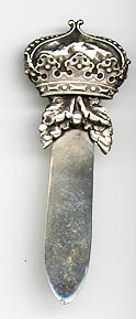 This bookmark was made in the US by Gorham. It is marked sterling, the hallmark for Gorham, 1569M and the date mark for 1887. The top is a figural crown with two leaves underneath it which are used as the top blade.