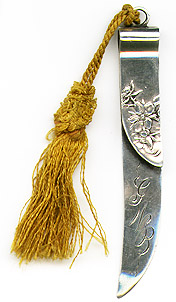 This bookmark was made in the US by Shiebler. It is marked with the makers hallmark, sterling and the number 2177. The top blade has relief flowers. The date is 1900 - 1910.