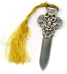 This bookmark was made in the US by an unknown manufacturer. It is marked sterling. The top a fancy art nouveau design, almost a filigree. It has a yellow silk tassel. The date is 1900 - 1910.