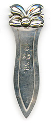 This bookmark was manufactured in Sweden. It is marked with the Swedish state marks and 830S. It has a figural flower on top. The front blade is marked 12/24 1938, no doubt a Christmas present for someone.